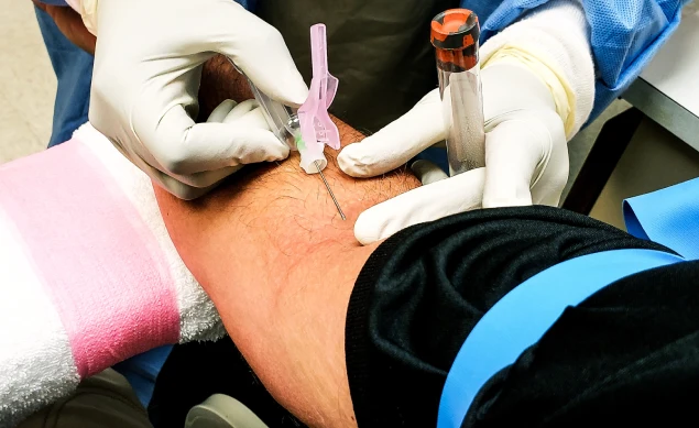 Phlebotomist collecting a blood sample at a patient's home